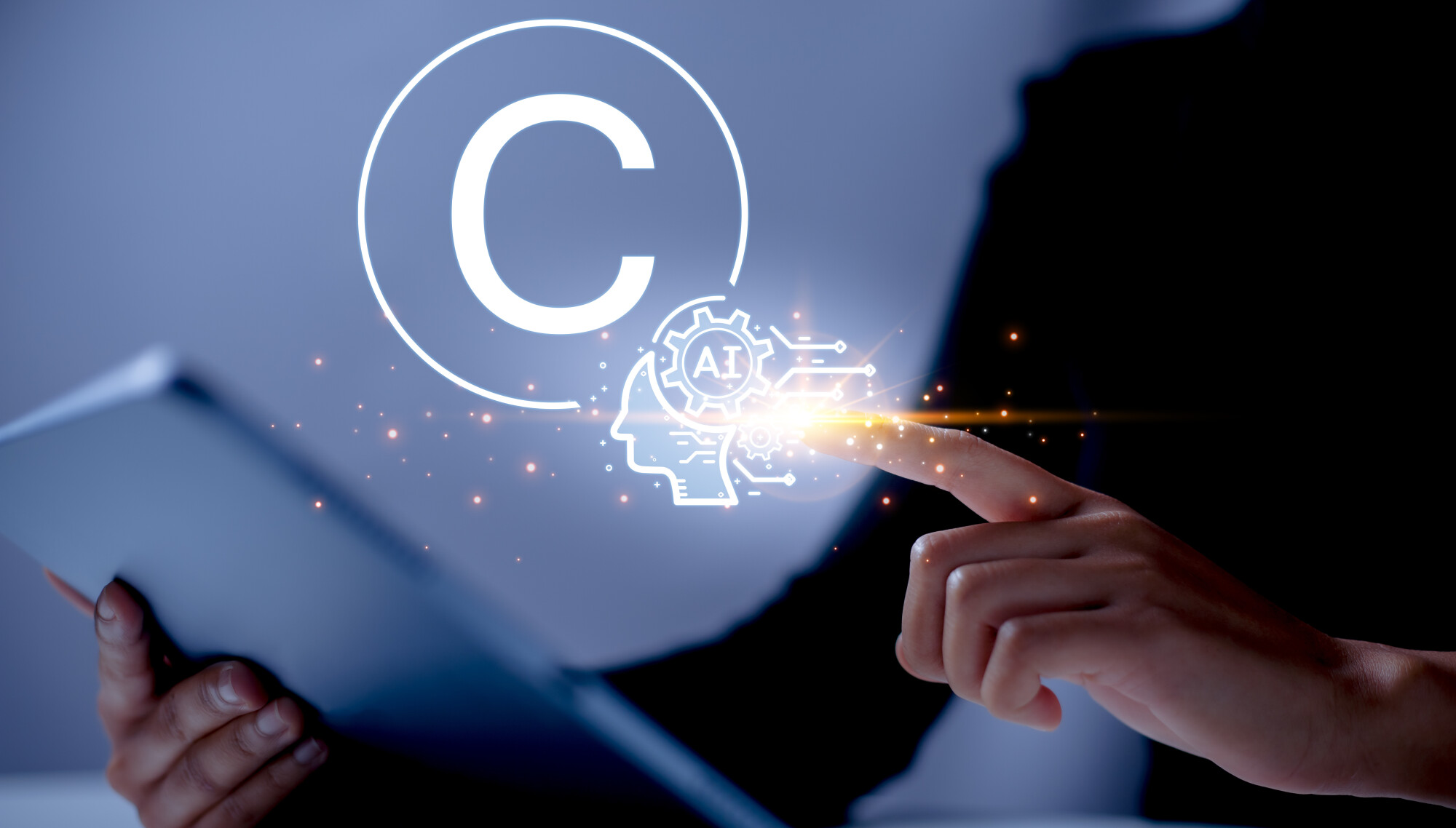 Hand holding tablet and finger points at copyright and AI icons