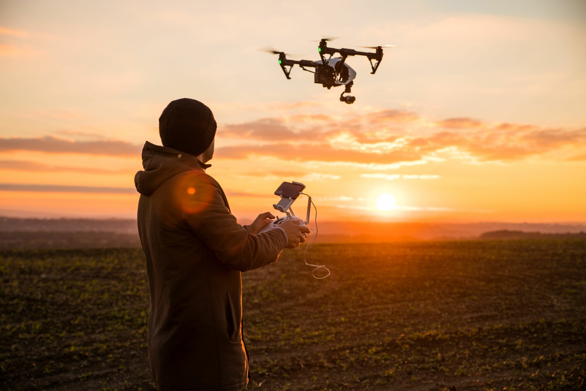 Man Flying Drone at Sunset