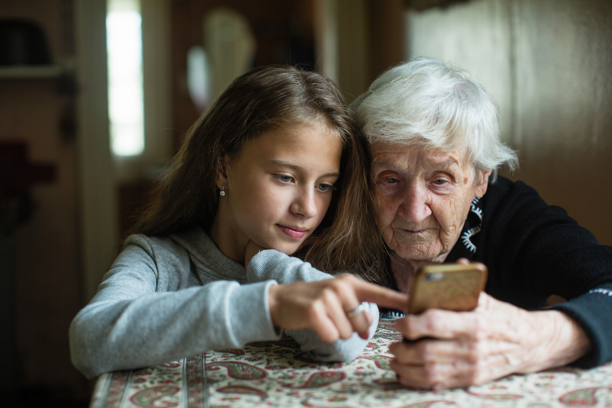 Granddaughter Assisting Grandmother with Phone